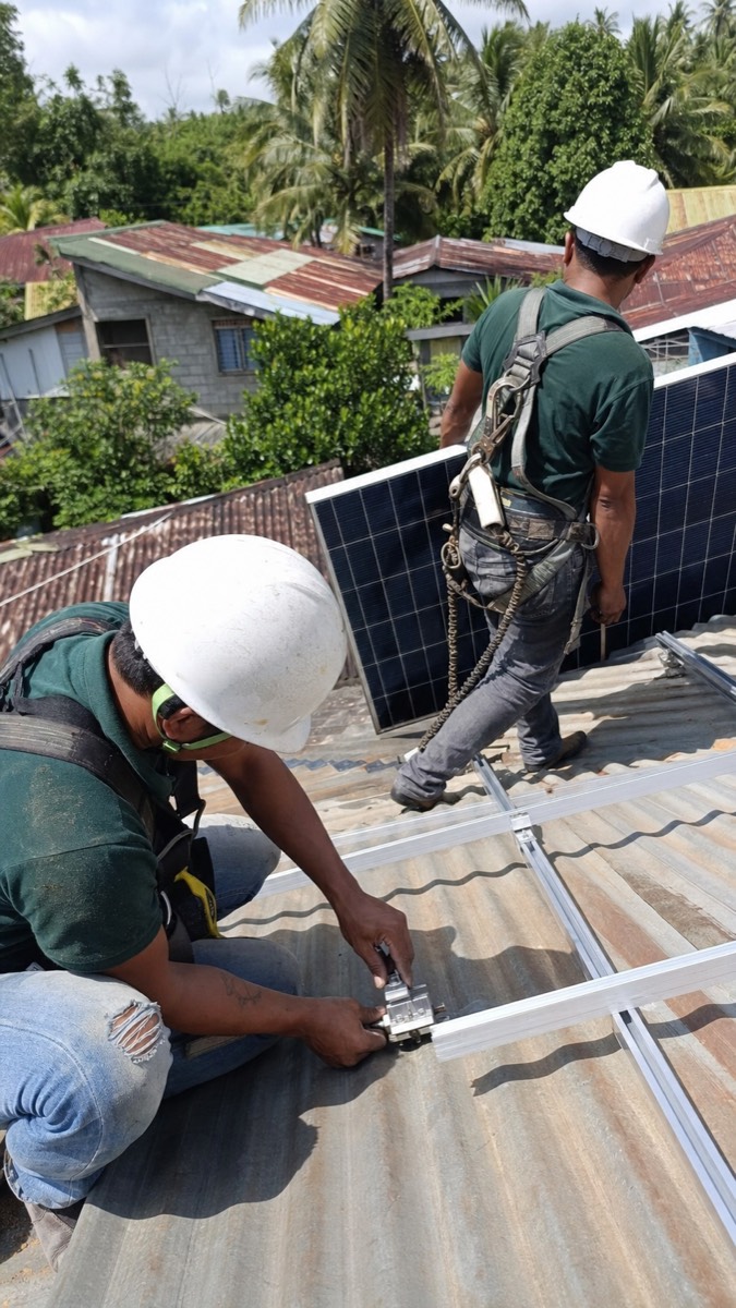 Illustrative image: installation team fitting solar panels on a home roof